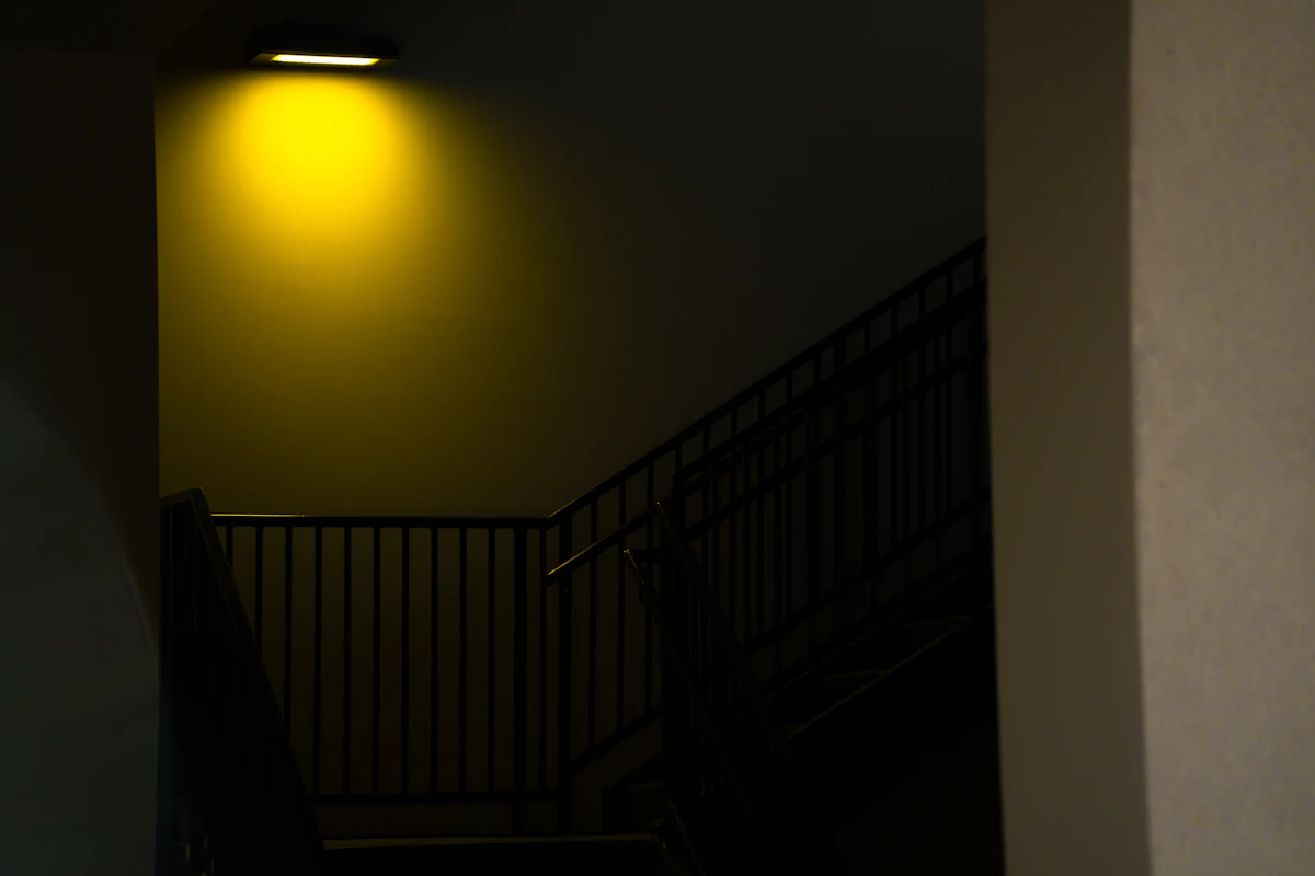 Escalier sombre éclairé par une seule ampoule