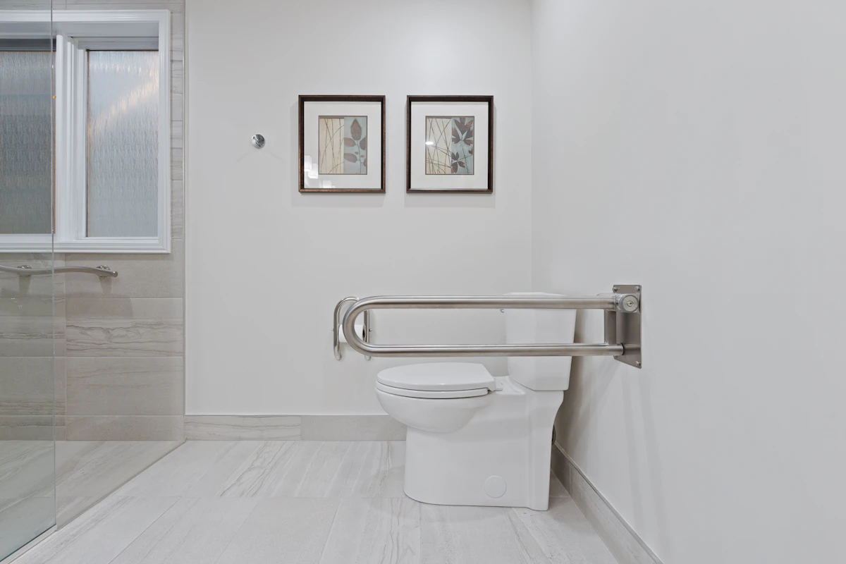 Salle de bain adaptée avec toilettes, baignoire et équipements d’appui