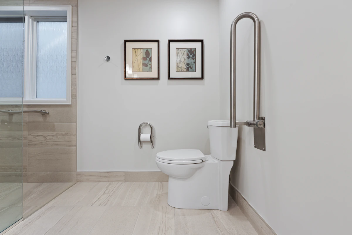Salle de bain adaptée avec WC et barre d’appui relevable