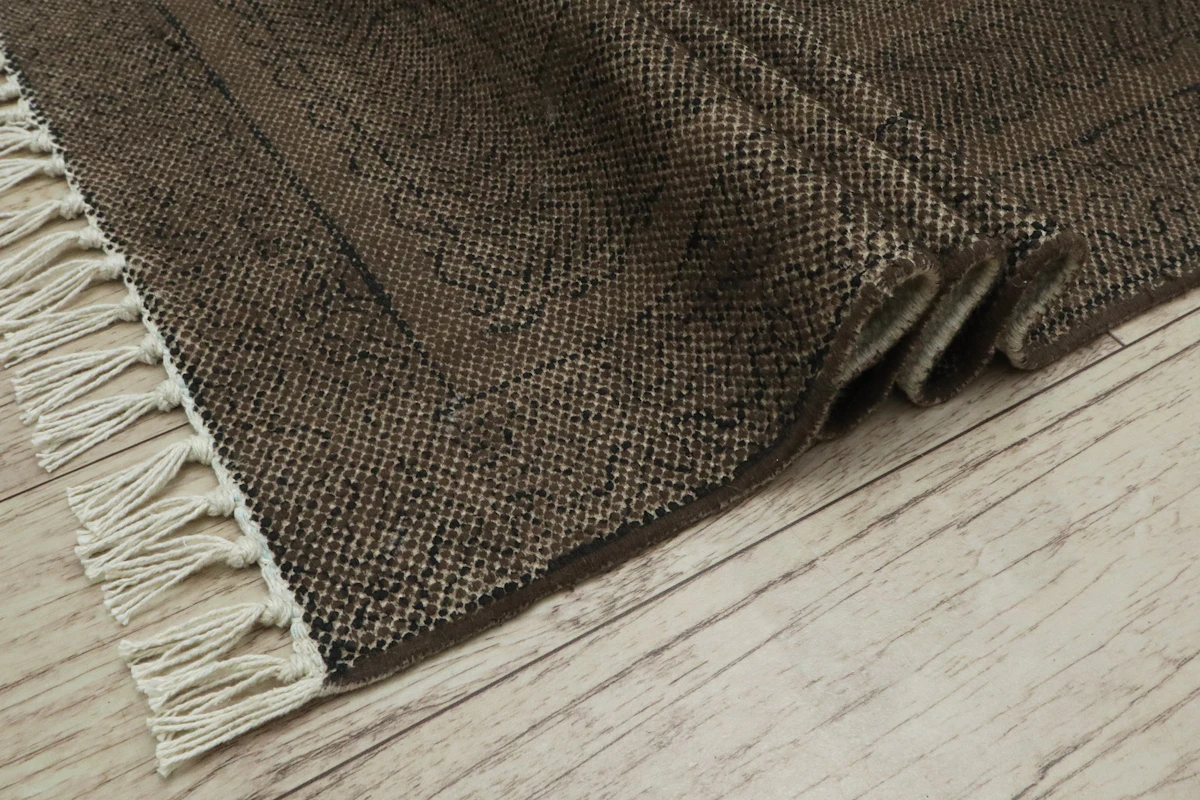 Tapis à franges posé sur un parquet
